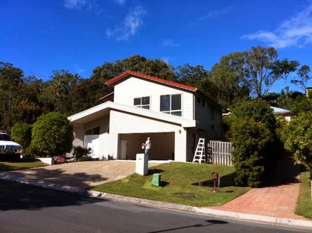 Exterior repaint in progress on a Brisbane home, ladder set up at the garage